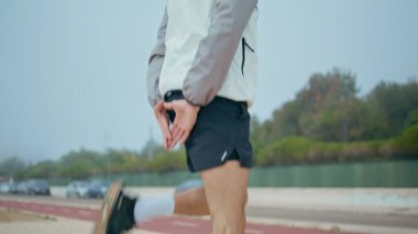 Koşucu bacakları ısınıyor. Sabahleyin sokakta profesyonel atlet eğitimi. Müzik dinleyen yakışıklı konsantre sporcu yarış maratonuna hazırlanıyor. Formda kaslı adam sokaklarda kardiyo yapıyor.