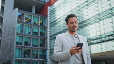 Ciddi bir çalışan, iş bölgesindeki el cihazını arıyor. Kapatın. İspanyol iş adamı şehir merkezinde kulaklık takarak akıllı telefondan konuşuyor. Resmi giysi kendine güvenen avukat danışma istemcisi