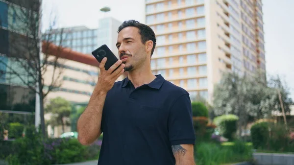 Casual director recording voice message at downtown closeup. Successful man using mobile phone virtual assistant at business district. Relaxed businessman consult client sending audio. Digital life