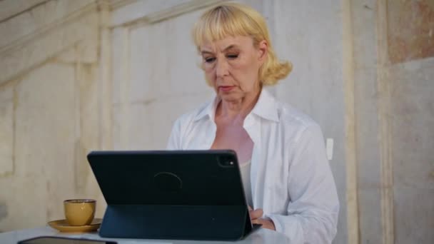 资深企业家在户外咖啡店里浏览平板电脑 严肃而成熟的女人想工作时在街上打字笔记本电脑键盘 漂亮优雅的祖母坐在网吧里冲浪 — 图库视频影像