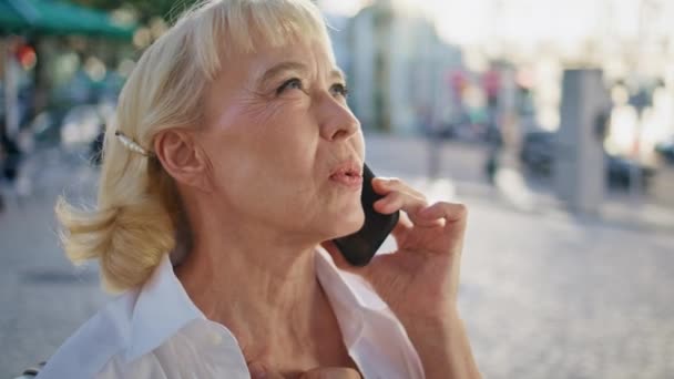 햇볕이 거리에서 전화를 옥외에 스마트 말하는 우아한 아름다운 은퇴자의 초상화 — 비디오
