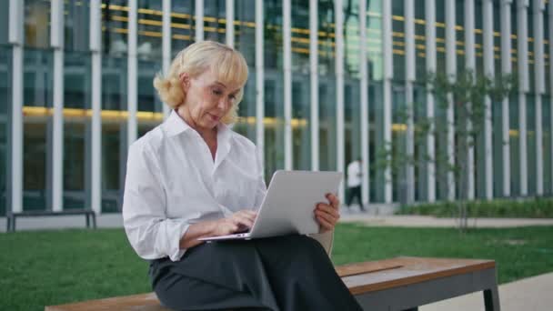 Elderly Businesswoman Typing Text Laptop Sitting Street Bench Close Beautiful — Stock Video