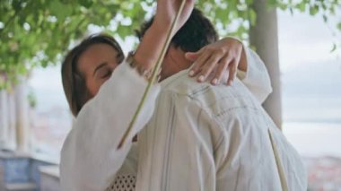 Şehirler arası terasta romantik bir buluşma. Yakın plan. Şehvetli güzel bir kadın çiçek kokluyor yeşillik caddesinde erkek arkadaşına sarılıyor. Sevgili eşlerin kucaklaşması rahat bir parkta birbirlerine bağlanmaları.