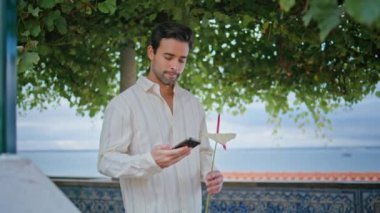 Randevu adamı, akıllı telefonları kontrol ediyor. Nazik çiçekli kadın yakından bakıyor. Yakışıklı esmer, yeşil ağaçların altında gülümseyen iyi haberler okuyor. Romantik maço Akdeniz şehir balkonunda dinleniyor
