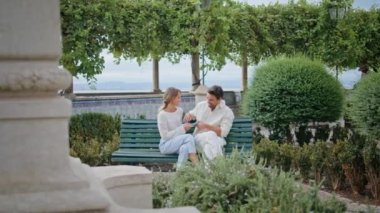 Şehir parkında oturan neşeli çift gülüyor. Romantik bir randevuda elinde kitap tutan şefkatli bir adam bir kadına komik bir hikaye anlatıyor. Yeşillik doğasında öpüşmekten keyif alan güzel bir çift. 