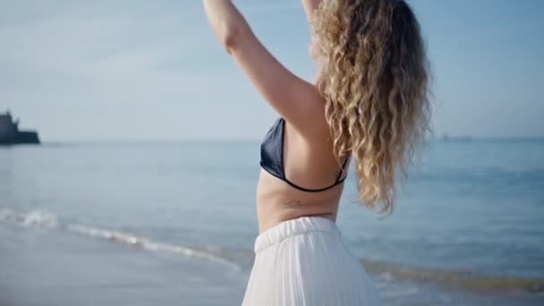 美しい海の波を楽しむ現代のパフォーマーダンスビーチ 海岸で現代的な振付を練習するベアフットカーリー女性 湿った砂の夏の日に体を動かす感覚的な少女 — ストック動画