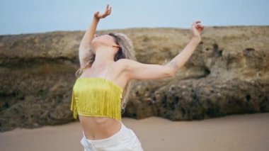 Dans eden ve kameraya bakan ilham verici kadın, baştan çıkarıcı bir şekilde yaklaş. Güzel esnek kız dansçı doğa üzerinde çağdaş koreografi sergiliyor. Muhteşem kadın sanatçı dans ederek ellerini havaya kaldırıyor..