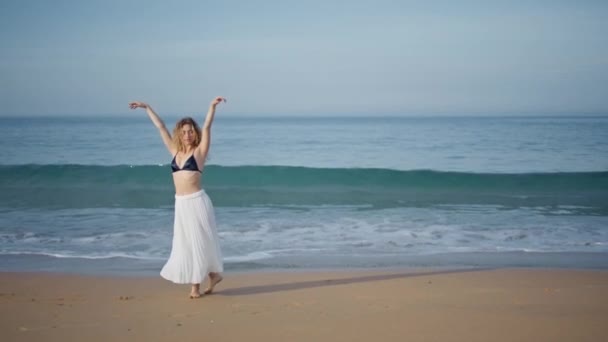 美しい砂浜の夏の夜に踊るロマンチックな少女 海岸で優雅な動きを踊るプロのカーリー振付家 海の波でダンスを即興させる官能ダンサー — ストック動画