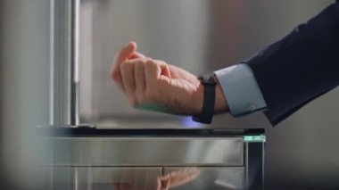 Uyanık dokunmatik sensör kontrol paneli ile ofis turnikesini açıyorum. İş merkezinde kimlik kontrolü için dijital saat kullanan tanınmayan bir işadamı.