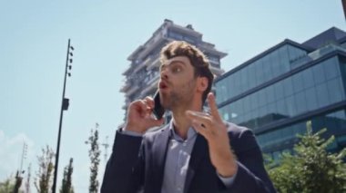 Şehir merkezinde cep telefonuyla kavga eden kızgın bir adam var. Sinirli iş adamı akıllı telefondan bağırarak sokaklarda hayal kırıklığı yaratıyor. Öfkeli yönetici telefonla iş başarısızlığını tartışıyor.