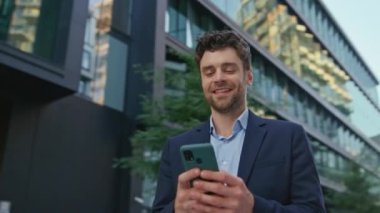 Çekici bir yönetici cep telefonuyla şehir merkezini kapatıyor. Ofis müdürünün açık hava molasında akıllı telefonla mesajlaşması. Gülümseyen iş adamı SMS okuyor. Kamera hareket ediyor.