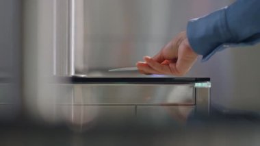 Kadın eli ofis binasına girmek için giriş kartını kullanıyor. Tanımlanamayan iş kadını girişteki elektronik sensör kapısına kimlik kartı uyguluyor. Güvenlik sisteminde yürüyen bir kadın.