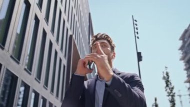 Kızgın girişimci cep telefonu konuşmasına bağırarak Sunny Caddesi 'ni kapatıyor. Duygusal kızgın iş adamı telefonda gergin bir şekilde bağırıyor. Akıllı telefondan kavga eden öfkeli bir adam ofis işi yapıyor..