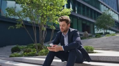 Cep telefonu interneti tarayan çekici girişimci sokak merdivenlerini kapatıyor. Rahat menajer dışarıda cep telefonuyla sosyal medyayı izliyor. Zarif iş adamı akıllı telefondan mesaj yazıyor