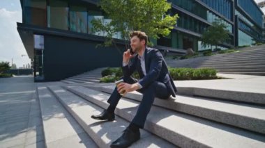 Mutlu serbest çalışanlar kahve molasında arıyor şehir merdivenlerinde oturuyor güneşli bir sabah zum yapıyor. Yakışıklı iş adamı akıllı telefondan içki siparişi veriyor. Gülümseyen adam sokakta dostça konuşmaktan hoşlanır..