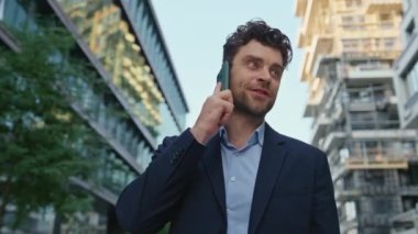 Başarılı bir iş adamı caddede iş görüşmesi için arıyor. Akıllı telefondan bahseden yakışıklı bir adam modern yerleşim yerinde duruyor. Zarif girişimci açık havada cep telefonuna danışmanlık yapıyor..
