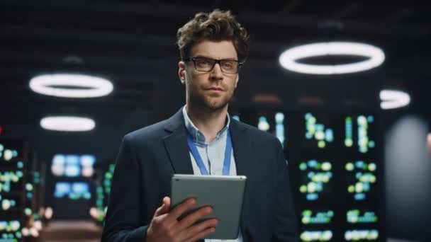 微笑的软件工程师在数据中心的特写中保存着平板电脑 成功的信息技术经理摆出一副技术办公室肖像的样子看着相机 在黑暗房间里戴眼镜的阳性男人 — 图库视频影像
