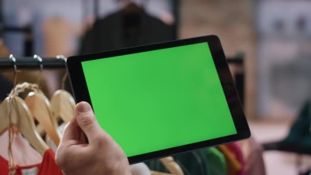 モダンなファッションショップのクローズアップで染色体タブレットコンピュータに触れる男の手 トレンディなモールで働く緑色のスクリーン パッドをタイプする認識できないスーパーバイザー 職場でモックアップデジタルタブを使用したストアワーカー — ストック動画