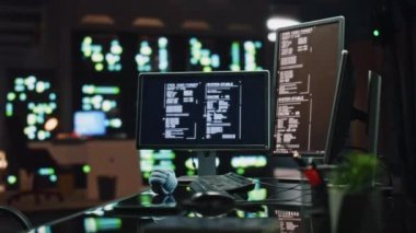 Gece ofisindeki veri yazılımı işyerini iki monitörden izliyoruz. Programlama dili içerikli bilgisayar. Boş karanlık kontrol sunucu odasında dijital aygıtlar. İnsan yok. Gözlükler masada yatıyor.