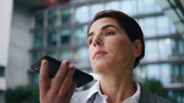 Kapanış işkadını ofiste mesaj kaydediyor. Odaklanmış yönetici cep telefonu şehir merkezine sesli mesaj gönderiyor. Sanal asistanla kendine güvenen bir yönetici konuşması. Dijital yaşam tarzı kavramı.