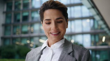 Gülümseyen menajer akıllı telefonları kullanarak selfie çekiyor. Kurumsal bir kadın öğle yemeği molasında modern ofis merkezinde fotoğraf çekiyor. Neşeli işkadını işçi cep telefonuyla sosyal medyanın keyfini çıkar