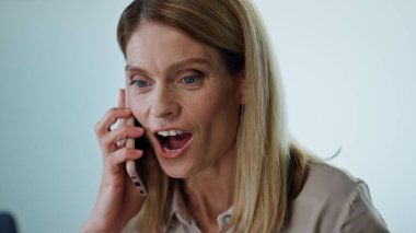 Ofis portresindeki akıllı telefondan konuşan heyecanlı yönetmen. Mutlu iş kadını cep telefonuyla duygusal bir konuşma yaparak başarıyı kutluyor. Gülümseyen bayan konferans odasında neşe içinde arama yapıyor.