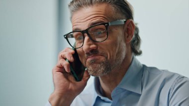 Ofiste cep telefonuyla konuşan gülümseyen bir işadamı. Akıllı telefondan konuşan yakışıklı bir portre sohbetinin keyfini çıkar. Gözlüklü neşeli çalışan, uzak bir iş yerinden cep telefonunu arıyor..