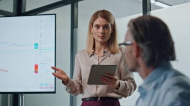 Ofiste ekranı gösteren ilham verici bir kadın. Toplantı odasında kendine güvenen kadın hoca akıl hocaları. Başarılı girişimci, kurul odasında açılışı sunuyor. İş konferansı kavramı 