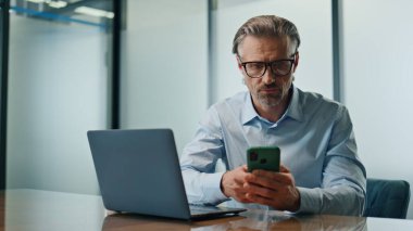 İşyerinde cep telefonunu daktilo etmekle meşgul bir yönetici. İşletme binasında bilgisayar kontrolü yaparak CEO 'luğa odaklanmış. Kendine güvenen Avrupalı işadamı çalışma araçları. Şirket yaşam konsepti 