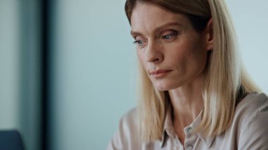 Ofis portresinde çalışan ciddi bir kadın. İş kadını elleri masa başında dizüstü bilgisayarı klavyesini daktilo ediyor. Düşünceli yönetici sadece boş dolaptaki e- postaları yanıtlamak için düğmelere basar