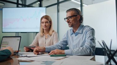 İş ortakları kapalı mekanda el sıkışıyor. Finans şirketinde anlaşma yapan mutlu insanlar. İş adamları kabine içlerinde başarılı bir ortaklığı kutlayan bir sözleşme imzaladılar 