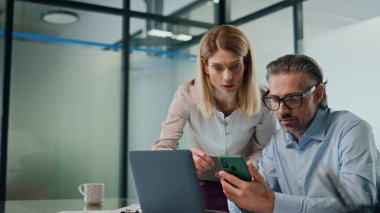 Ofiste birlikte çalışan iki çalışan yakın plan. Kendine güvenen iş adamları açık alanda bilgisayar projesini tartışıyor. Meslektaşlar kabine içinde toplantı yapıyorlar. Şirket iş kavramı 