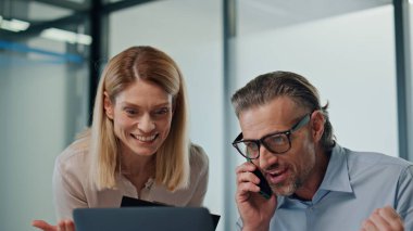 Aşırı neşeli iş adamları modern ofiste seviniyor. Heyecanlı meslektaşlar, beş başarıyı birlikte yakından izliyorlar. Sakallı işadamı evet diyerek telefonu arıyor. İş ortakları proje kazanıyor