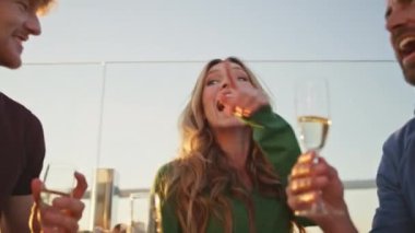 Yazın çatı katındaki partide dans eden aşırı neşeli arkadaşlar. Kapatın burayı. Şampanya bardaklarıyla müzik eşliğinde şarkı söyleyen gamsız insanlar. Grup tebessüm arkadaşları akşam vakti birlikte eğleniyorlar..