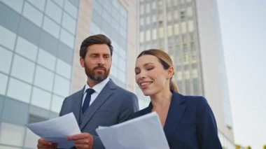 Konuşan yöneticiler iş belgeleriyle sokakta yürüyorlar. Mutlu başarılı ortaklar iş görüşmelerini tartışıyor. Belgeler ofise gidiyor. Gülümseyen iş kadını sakallı avukata kontrat veriyor.