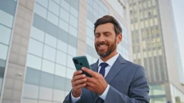 Ofisten çıktıktan sonra cep telefonuyla eve yürürken sosyal medyayı karıştıran rahat bir çalışan. Sakallı yakışıklı, akıllı telefon ekranına bakıp gülümsüyor. Mutlu işçi maaş bankası bildirimi okuyor.