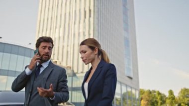 Yürüyen meslektaşlar işi yakından tartışıyor. Sakallı işadamı cep telefonunu arıyor ve dışarıda çalışan güzel bir kadınla ofise gidiyor. İki iş ortağı acele ile şehir caddesinde buluşuyor..