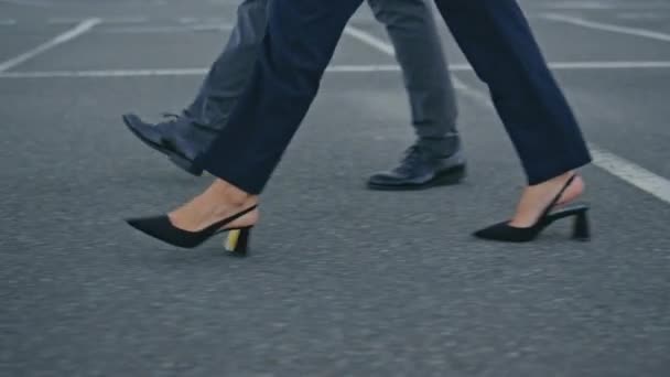 ビジネスの人々は 近い会議に急いで街の舗装を踏み出しています 見知らぬ二人の同僚が街路を歩いている エレガントな靴で町の歩道に行く成功したオフィスパートナー — ストック動画