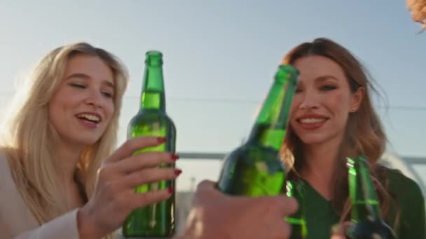 Улыбающиеся Друзья Тосты Бутылки Пива Летней Крыше Закрываются Беззаботные Люди — стоковое видео