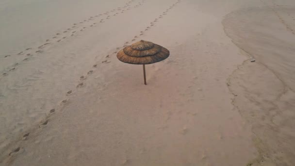 Одинокий Соломенный Зонтик Пустым Видом Пляж Бежевая Песчаная Поверхность Отпечатками — стоковое видео