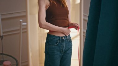 Eller aynadaki yansıma şeridini tutuyor. Yakından. Zayıf kız kilo verme sürecini kontrol ediyor. Mükemmel vücut şekline hayran. Neşeli, mutlu bir kadın fitness başarısından zevk alıyor. Diyet motivasyon kavramı