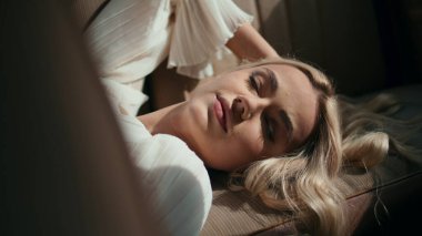 Sarışın kız arka koltukta yatıyor yaz güneşinin tadını çıkarıyor. Muhteşem, nazik bir kadın, sakin hissediyor. Eskimiş arabada, beyaz elbiseli rahat poz veriyor. Klasik bir araçta rahatlayan klas genç bir model..