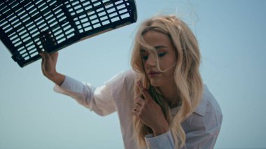 Kaputun altında motor arızası var gibi görünüyor. Kapıları kapatın. Kafası karışmış kadın sürücü, yaz günü kaput altında otomobil arızasını kontrol ediyor. Üzgün genç sarışın gezgin araba kazasını hayal kırıklığına uğrattı..