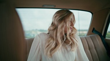 Rahat model otomobil arka koltuğu yakın çekim. Güzel bayan yolcu, eski arabanın içinde binmek için bekliyor. Klasik lüks bir arabada rahatlayan muhteşem sarışın kız. Seyahat konsepti.