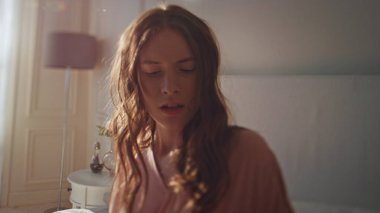 Sinirli kız sabahları hareketli görünüyor. Stresli uykulu kadın akıllı telefon kullanıyor. Gün ışığında cevapsız aramaları kontrol ediyor. Yatakta yatan, sosyal medya okuyan rahatsız bir kadın.