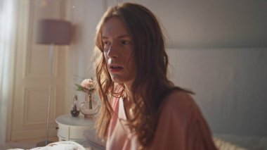 Kapalı kapılar ardında acı içinde uyanan bir kız. Mutsuz kadın karın ağrısı çekiyor. Yatakta karnına dokunuyor. Stresli güzel kadın evde acı veren kramplar geçiriyor. Hastalık gastrit konsepti