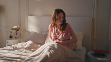 Karın ağrısı çeken bir kadın yatakta yatıyor. Evde karnı ağrıyan, mideye dokunan, karnı ağrıyan, hayal kırıklığına uğramış bir kız. Endişeli kadınların adet sancısı spazmları olur. Gıda zehirlenmesi