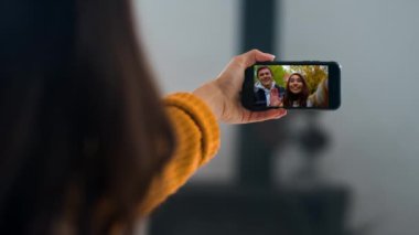 Kız arkadaşlarıyla görüntülü görüşme yapıyor. Kapalı el sallama evde cep telefonu tutarak. Mutlu çift tatilde haberleri paylaşıyor. Bilinmeyen bir kadın uzaktan kamerayla kız kardeşiyle konuşuyor..