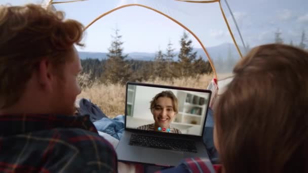 ハイキング旅行でカンファレンスをするケアフリーカップル ラップトップのスクリーンで振っている笑顔の女の子を閉じます 未知の旅行者が仮想会議アプリを話しています 山の休暇を休む観光客 — ストック動画