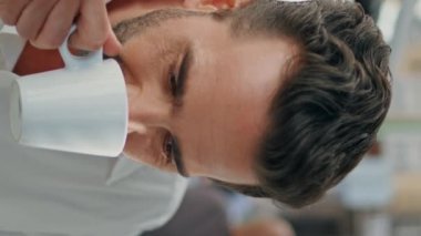 Şehir kafeteryasında dikey çekimde kahve içen düşünceli bir işadamı. Sakallı ve sakallı bir beyefendi yaz kafesinde oturmuş aroma içeceği yudumluyor. Gezgin restoranda güzel kokulu içkinin tadını çıkarıyor. 